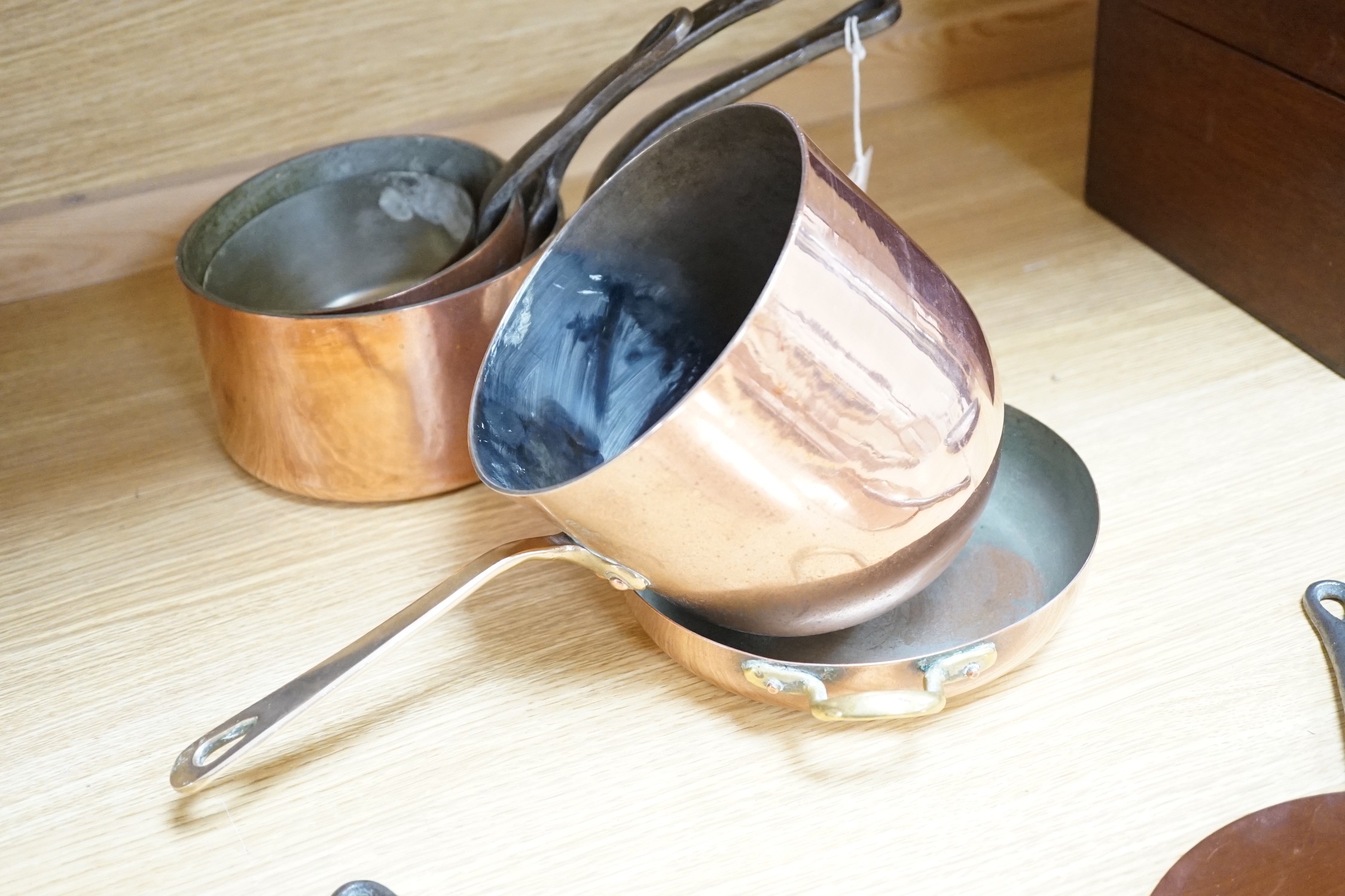 A quantity of copper pans including a zabaglione brass handled pan